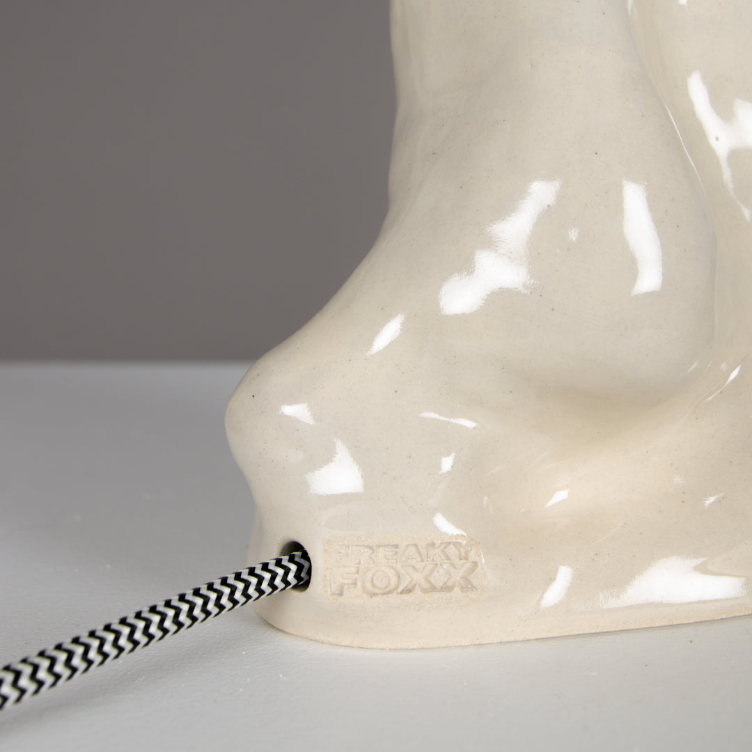 Back side of ceramic lamp with braided cord and signature detail – beige linen lampshade included. / Šviestuvo vaizdas iš nugaros su pintu laidu ir autoriniu žymėjimu – komplekte 100 % lino smėlio spalvos gaubtas.