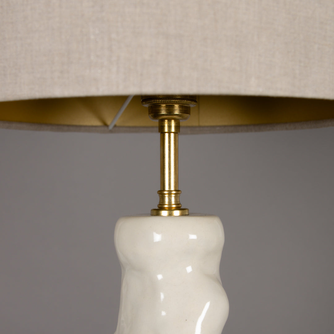 Close-up of 100% linen beige lampshade with brass fitting – elegant detail for premium handmade ceramic table lamps. / 100 % lino smėlio spalvos gaubtas su žalvariniu tvirtinimu – elegantiška detalė aukštos kokybės rankų darbo šviestuvui.