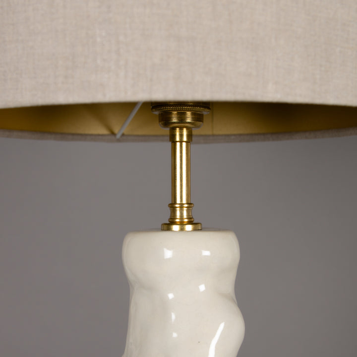 Close-up of 100% linen beige lampshade with brass fitting – elegant detail for premium handmade ceramic table lamps. / 100 % lino smėlio spalvos gaubtas su žalvariniu tvirtinimu – elegantiška detalė aukštos kokybės rankų darbo šviestuvui.