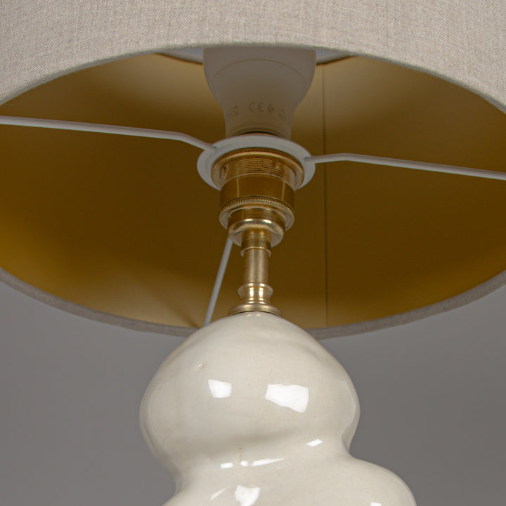 Underside of 100% linen lampshade with brass hardware – refined finishing on designer lamp. / 100 % lino gaubto apačia su žalvario detalėmis – išbaigtas dizainerio šviestuvo akcentas.