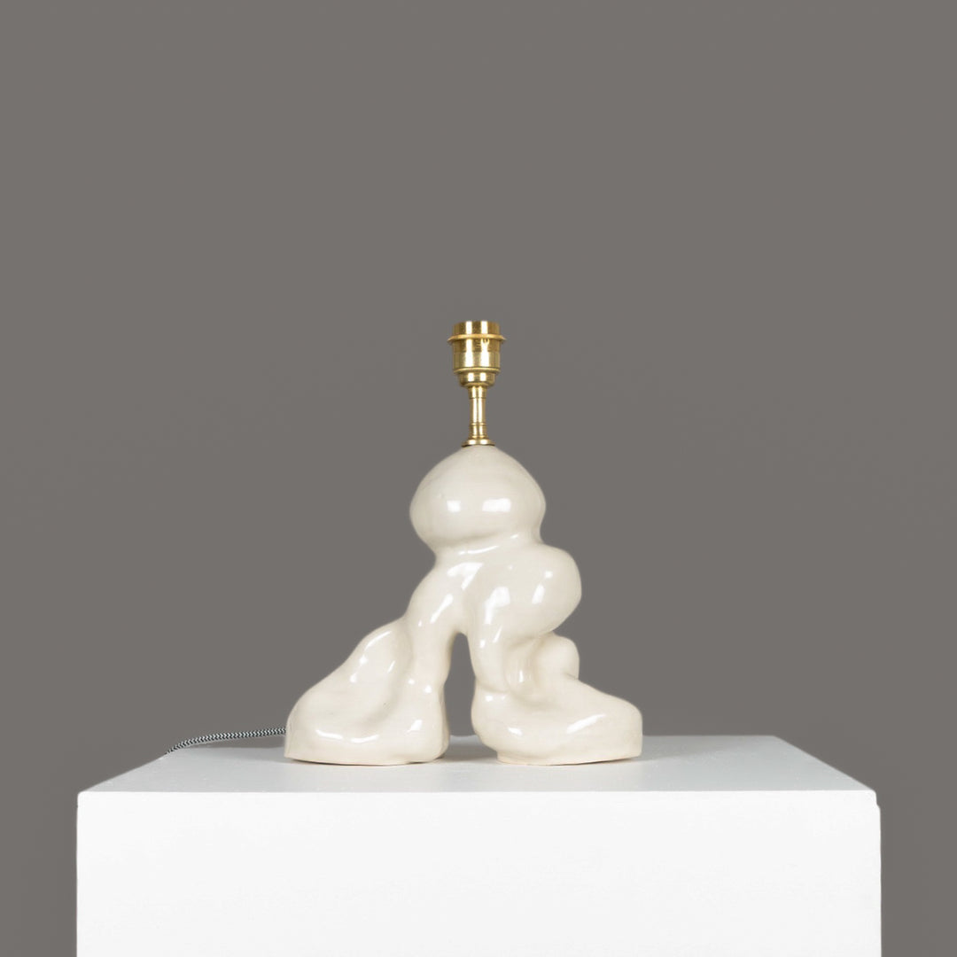 Organic form ceramic lamp base shown without shade – sculptural and minimalist lighting piece. / Natūralių formų keraminis šviestuvo pagrindas be gaubto – skulptūrinis, minimalistinis šviesos objektas.