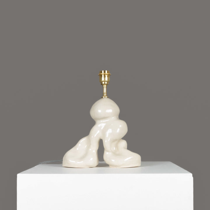 Organic form ceramic lamp base shown without shade – sculptural and minimalist lighting piece. / Natūralių formų keraminis šviestuvo pagrindas be gaubto – skulptūrinis, minimalistinis šviesos objektas.