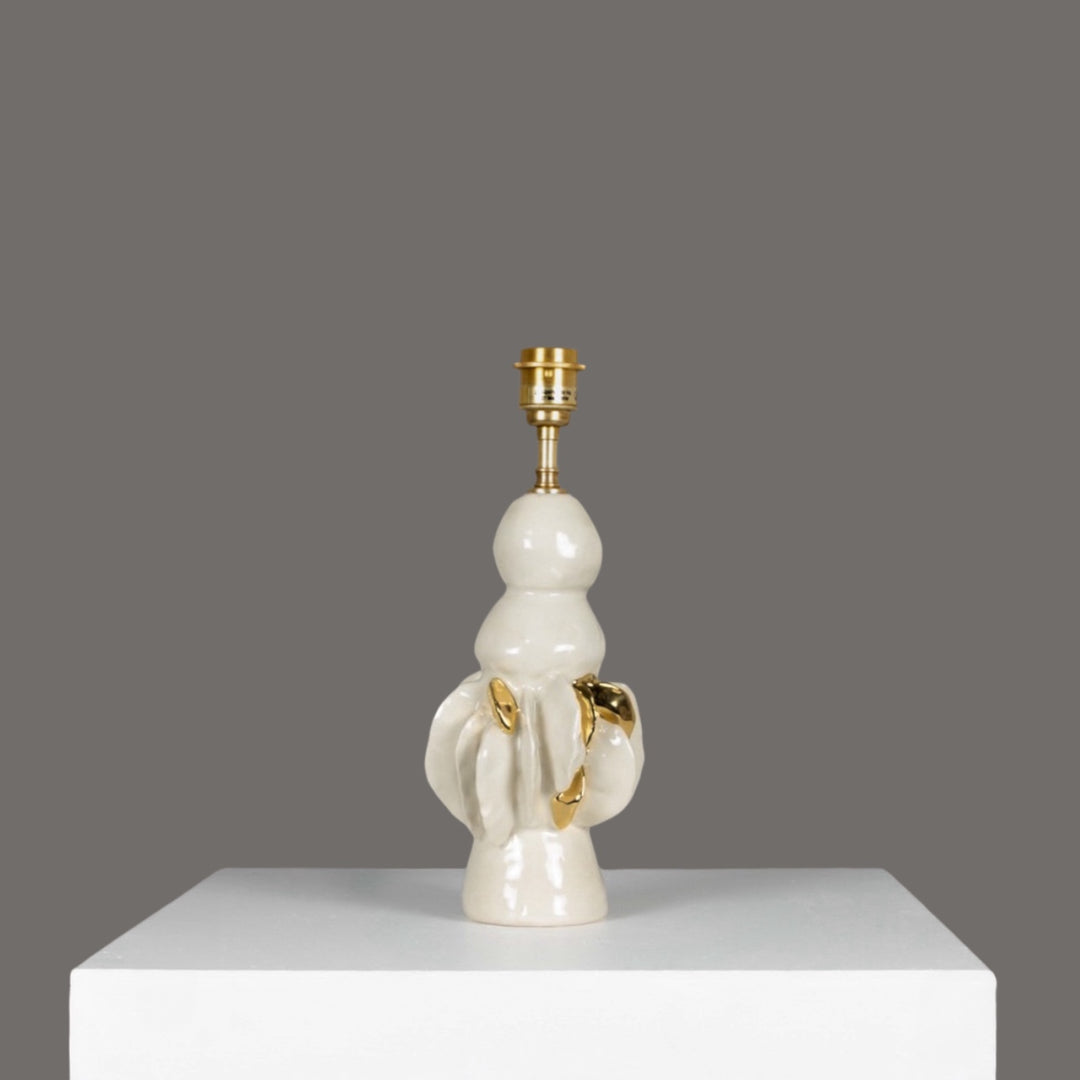 Glossy ceramic lamp base with golden sculptural accents – perfect for pairing with 100% linen beige lampshade. / Blizgus keraminis šviestuvo pagrindas su aukso akcentais – idealus derinys su smėlio spalvos lino gaubtu.