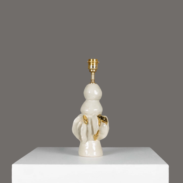 Glossy ceramic lamp base with golden sculptural accents – perfect for pairing with 100% linen beige lampshade. / Blizgus keraminis šviestuvo pagrindas su aukso akcentais – idealus derinys su smėlio spalvos lino gaubtu.