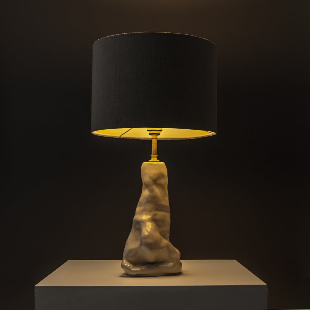Designer ceramic table lamp with beige linen lampshade glowing warmly – elegant accent light for living room or bedroom. / Dizainerio keraminis stalinis šviestuvas su lino gaubtu šviečia jaukiai – puikus akcentas svetainei ar miegamajam.