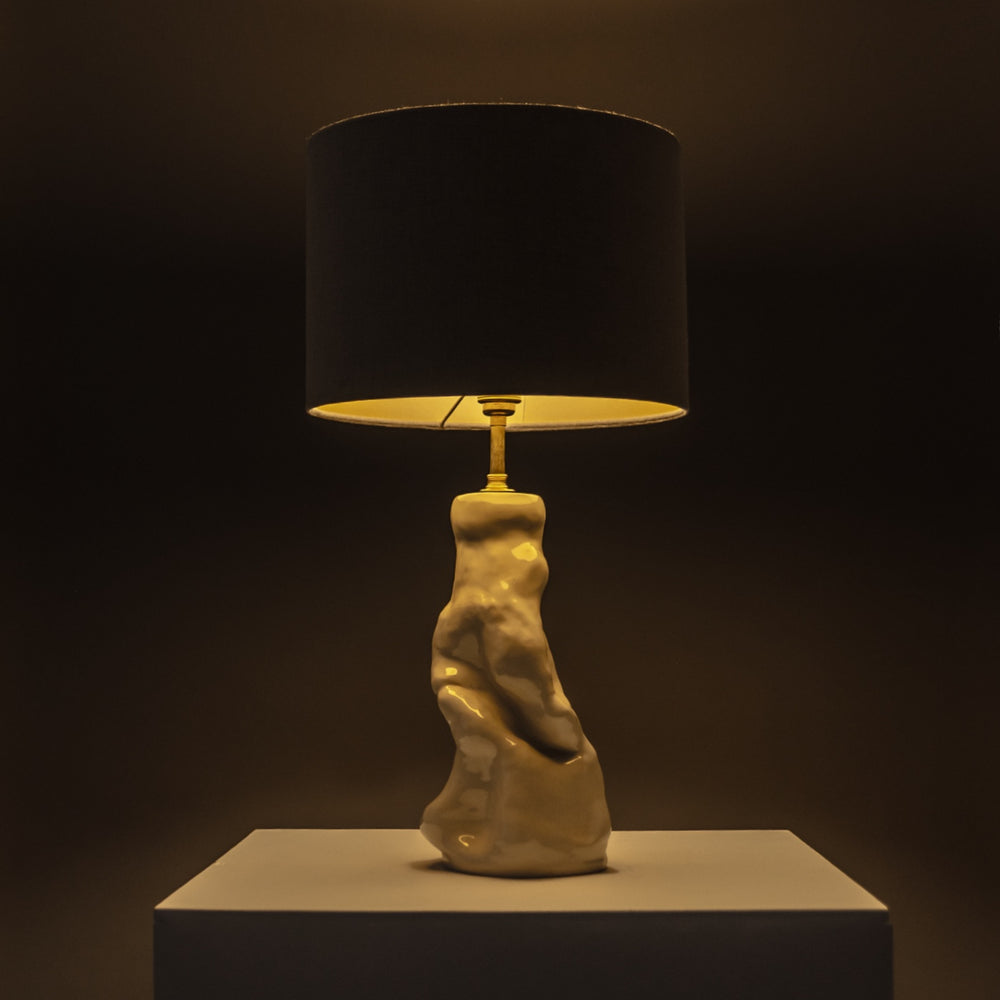 Handcrafted ceramic lamp glowing warmly in a dark space – statement lighting with a soft linen shade for moody, artistic interiors. / Rankų darbo keraminis šviestuvas su lino gaubtu šviečia jaukiai – puikus akcentas atmosferiškam interjerui.