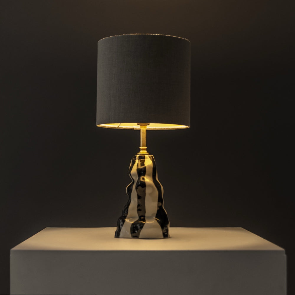 Ceramic table lamp glowing in a dark setting – ambient handmade lighting for cozy spaces and design lovers. / Keraminis stalinis šviestuvas šviečia jaukiai – puikus pasirinkimas mėgstantiems jaukų, išskirtinį apšvietimą.