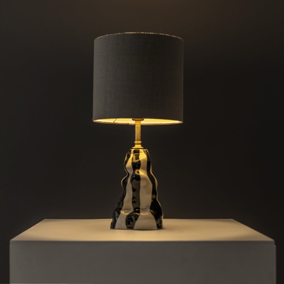 Ceramic table lamp glowing in a dark setting – ambient handmade lighting for cozy spaces and design lovers. / Keraminis stalinis šviestuvas šviečia jaukiai – puikus pasirinkimas mėgstantiems jaukų, išskirtinį apšvietimą.