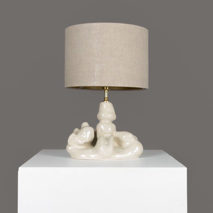 Artistic ceramic table lamp with sculptural base and 100% linen beige lampshade – a calm yet bold statement in modern interiors. / Meniškas keraminis stalinis šviestuvas su 100 % lino smėlio spalvos gaubtu – tylus, bet išraiškingas akcentas šiuolaikiniame interjere.