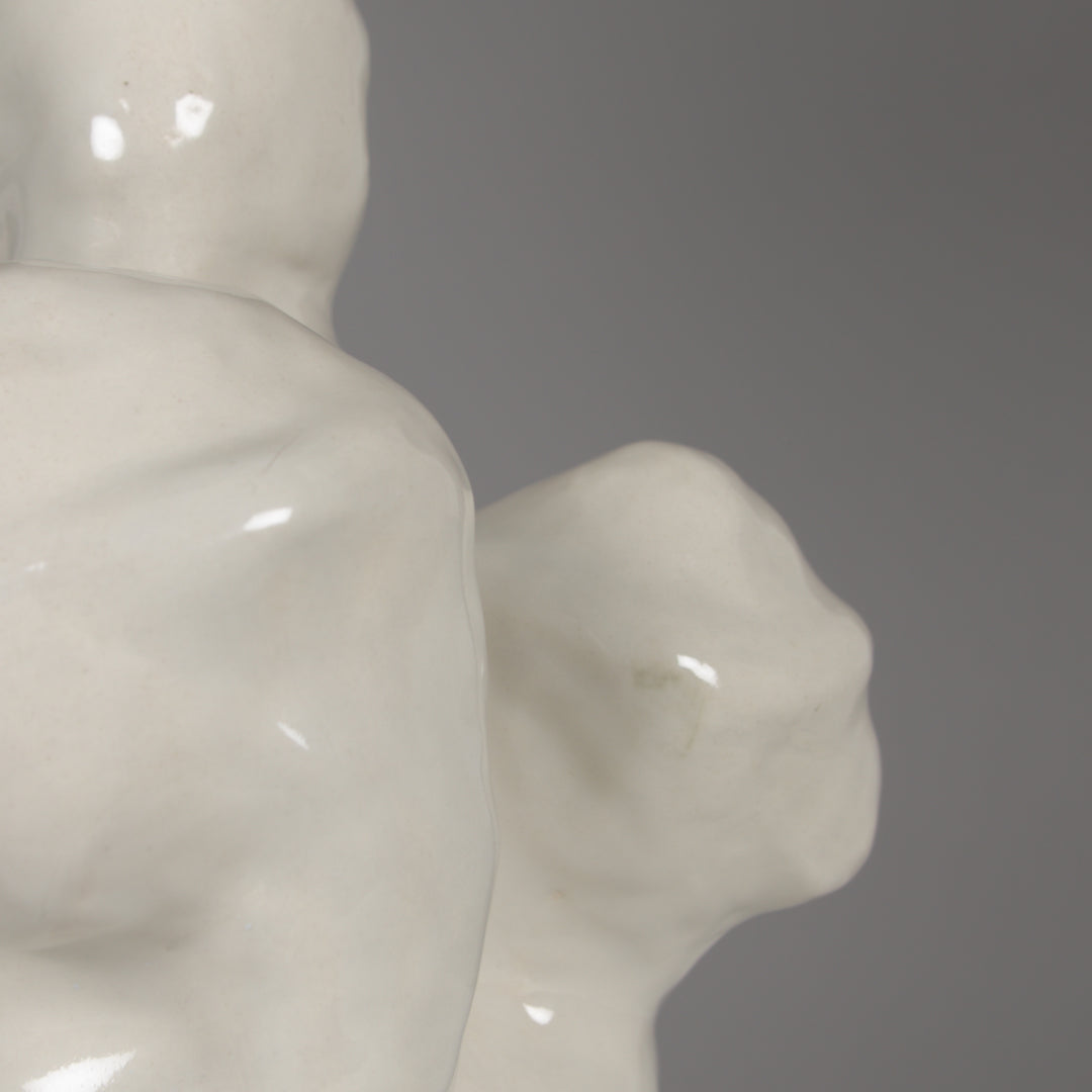 Detail of glossy ceramic hand-shaped base – functional art piece combining form and light. / Blizgi keraminė tekstūra, rankos forma – funkcionalus meno objektas, skleidžiantis šviesą.