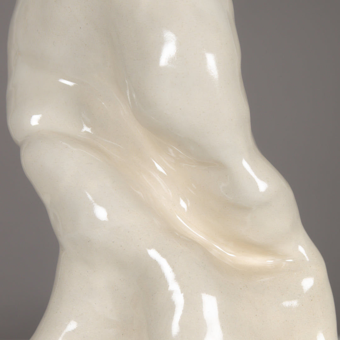 Glossy stoneware surface of sculptural lamp base – handmade ceramic design with organic flow and smooth glaze. / Blizgus akmens masės paviršius – skulptūrinio rankų darbo šviestuvo pagrindas su natūralia forma ir glazūra.