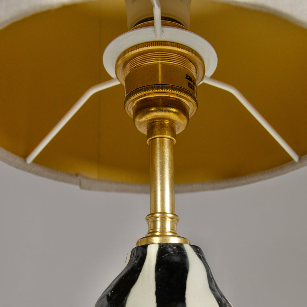Underside of lampshade with golden brass fitting – high-quality handmade detail in ceramic lighting. / Gaubto apačia su aukso spalvos žalvario detale – kokybiškas akcentas rankų darbo keraminiam šviestuvui.