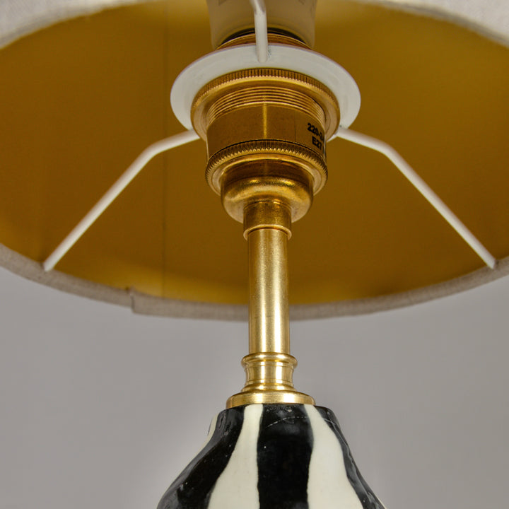 Underside of lampshade with golden brass fitting – high-quality handmade detail in ceramic lighting. / Gaubto apačia su aukso spalvos žalvario detale – kokybiškas akcentas rankų darbo keraminiam šviestuvui.