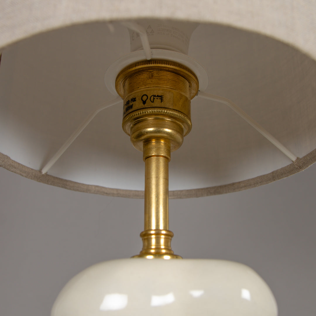 Underside of lampshade with brass fitting – quality detail in a handmade table lamp. / Gaubto apačia su žalvariniu laikikliu – kokybiška detalė rankų darbo stalinio šviestuvo dizaine.