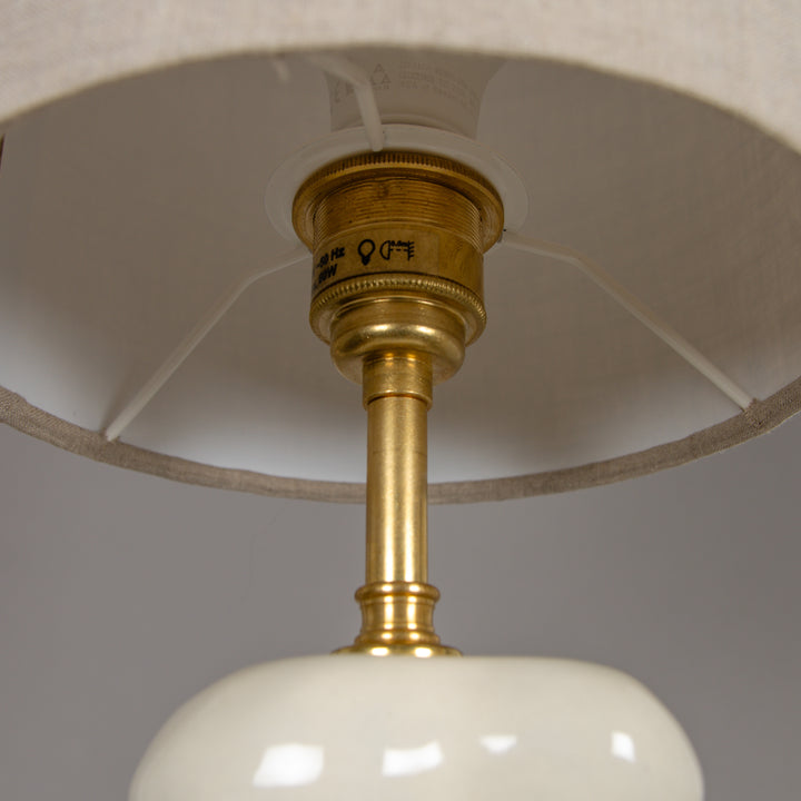 Underside of lampshade with brass fitting – quality detail in a handmade table lamp. / Gaubto apačia su žalvariniu laikikliu – kokybiška detalė rankų darbo stalinio šviestuvo dizaine.