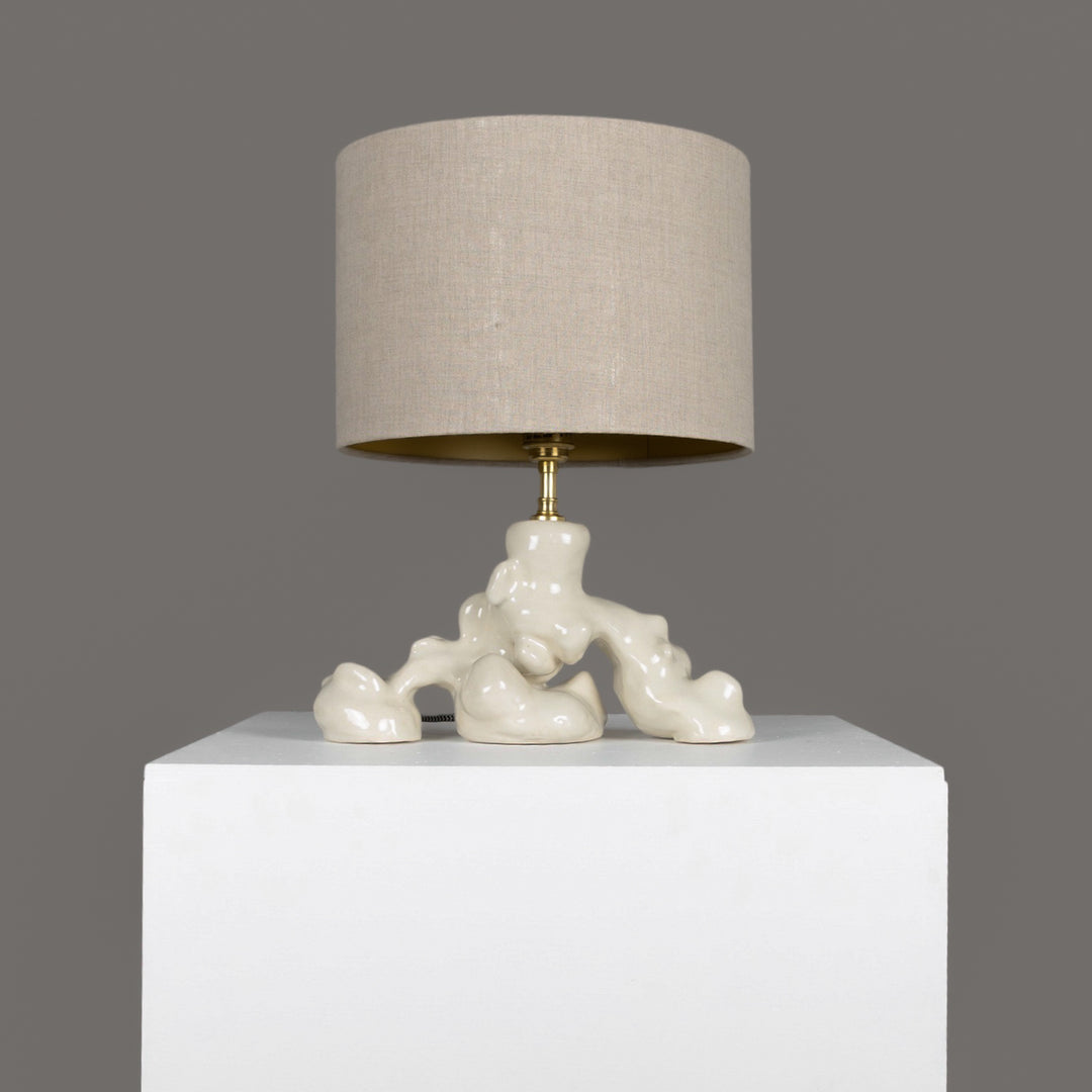 Organic sculptural ceramic table lamp with 100% linen beige lampshade – designed for calming, artful interior spaces. / Organinės formos keraminis stalinis šviestuvas su 100 % lino smėlio spalvos gaubtu – ramiai ir meniškai namų atmosferai.