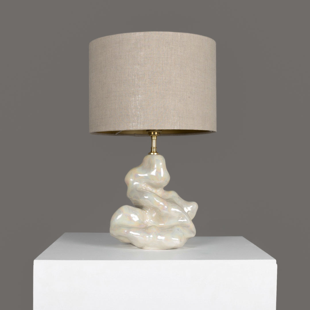 Sculptural stoneware table lamp with soft beige linen shade – handmade lighting for modern interiors. / Skulptūrinis akmens masės stalinis šviestuvas su šviesiu lino gaubtu – rankų darbo apšvietimas šiuolaikiniam interjerui.