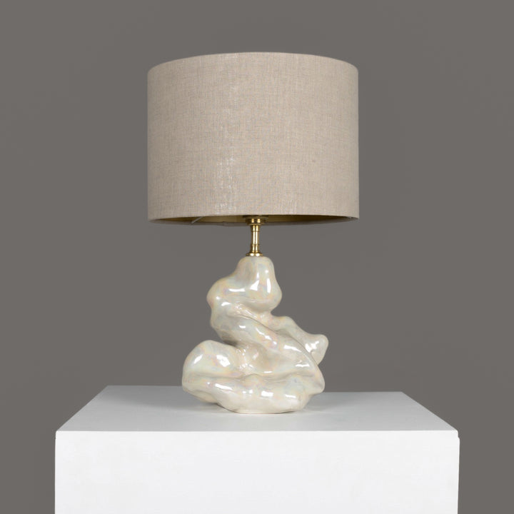Sculptural stoneware table lamp with soft beige linen shade – handmade lighting for modern interiors. / Skulptūrinis akmens masės stalinis šviestuvas su šviesiu lino gaubtu – rankų darbo apšvietimas šiuolaikiniam interjerui.