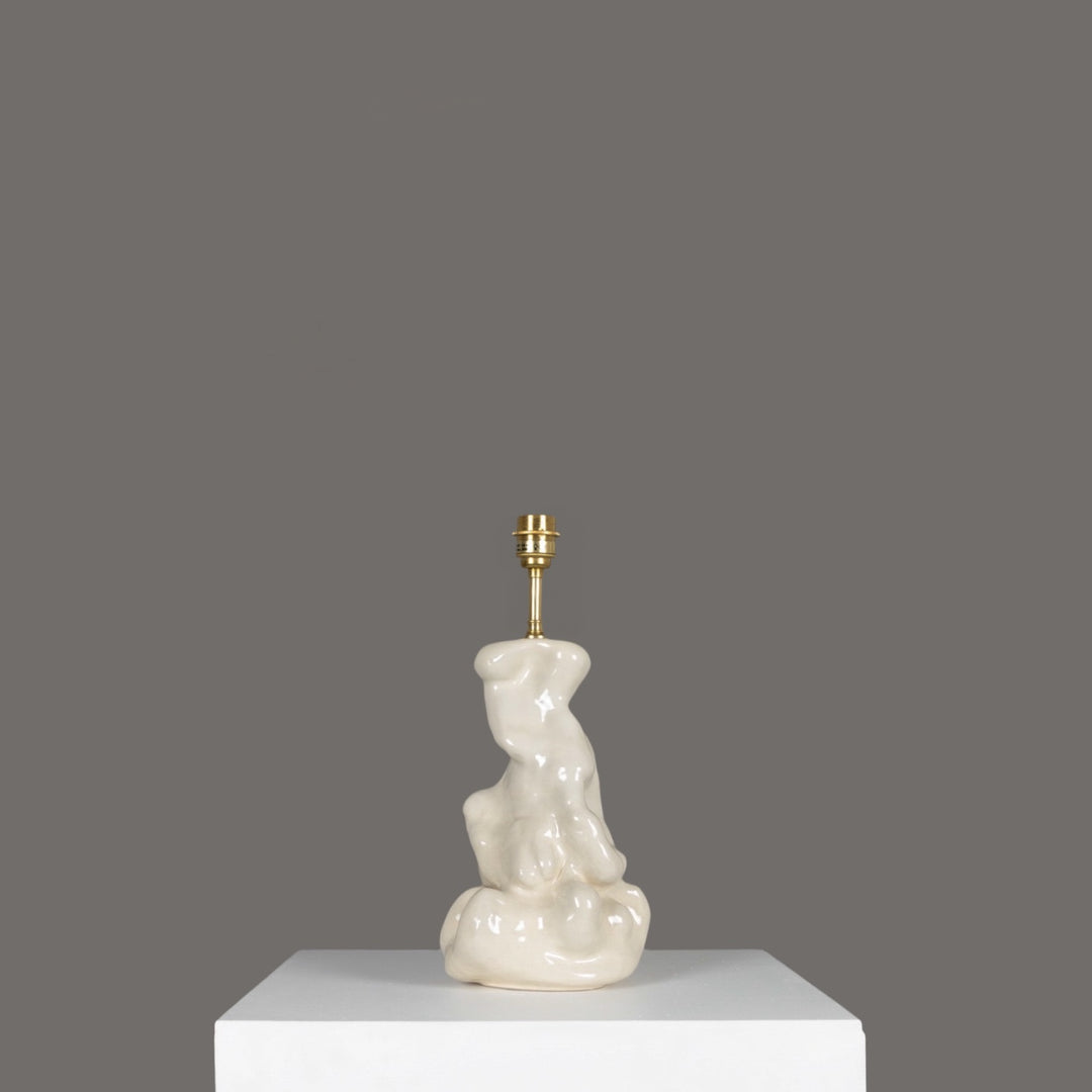 Side view of stoneware lamp with artistic base – ceramic lighting that blends design and function. / Akmens masės šviestuvas iš šono su menišku pagrindu – keraminis apšvietimas, kuriame dera dizainas ir funkcija.