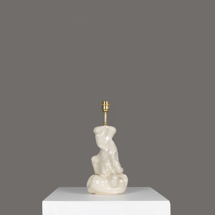 Side view of stoneware lamp with artistic base – ceramic lighting that blends design and function. / Akmens masės šviestuvas iš šono su menišku pagrindu – keraminis apšvietimas, kuriame dera dizainas ir funkcija.