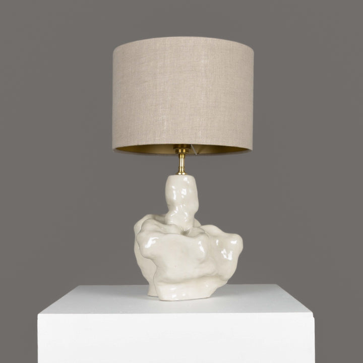 Side angle of sculptural stoneware lamp – minimal yet character-filled lighting with a neutral 100% linen lampshade. / Šoninis vaizdas – skulptūrinis akmens masės šviestuvas su natūraliu lino gaubtu.