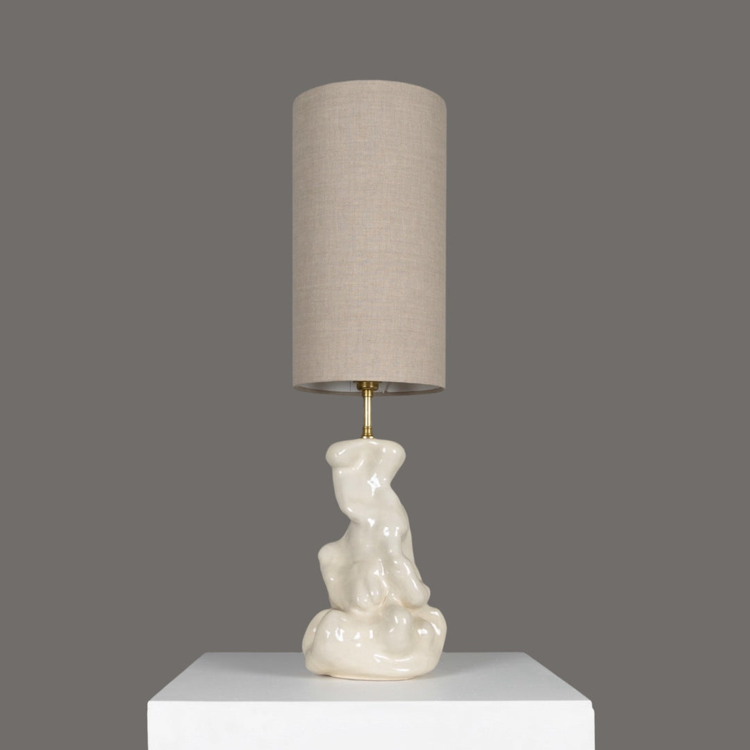 Sculptural stoneware table lamp with tall linen lampshade – elegant functional art piece for refined interiors. / Skulptūrinis akmens masės stalinis šviestuvas su aukštu lino gaubtu – elegantiškas ir funkcionalus interjero akcentas.
