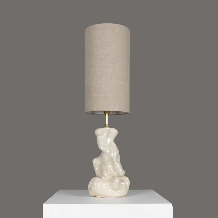 Sculptural stoneware table lamp with tall linen lampshade – elegant functional art piece for refined interiors. / Skulptūrinis akmens masės stalinis šviestuvas su aukštu lino gaubtu – elegantiškas ir funkcionalus interjero akcentas.