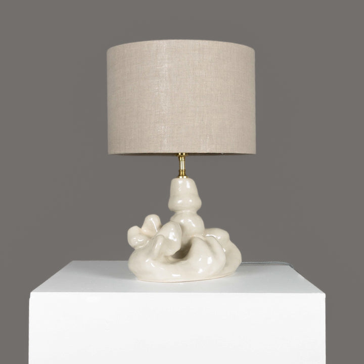 Side view of a stoneware table lamp with 100% linen shade – subtle shine and handmade character for any room. / Akmens masės stalinio šviestuvo šoninis vaizdas su lino gaubtu – subtilus žvilgesys ir rankų darbo charakteris.