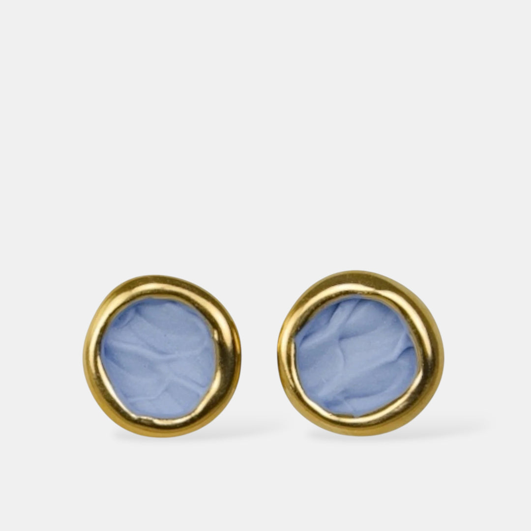 Pair of gold earrings with matte blue porcelain centers on a white background by freakyfoxx