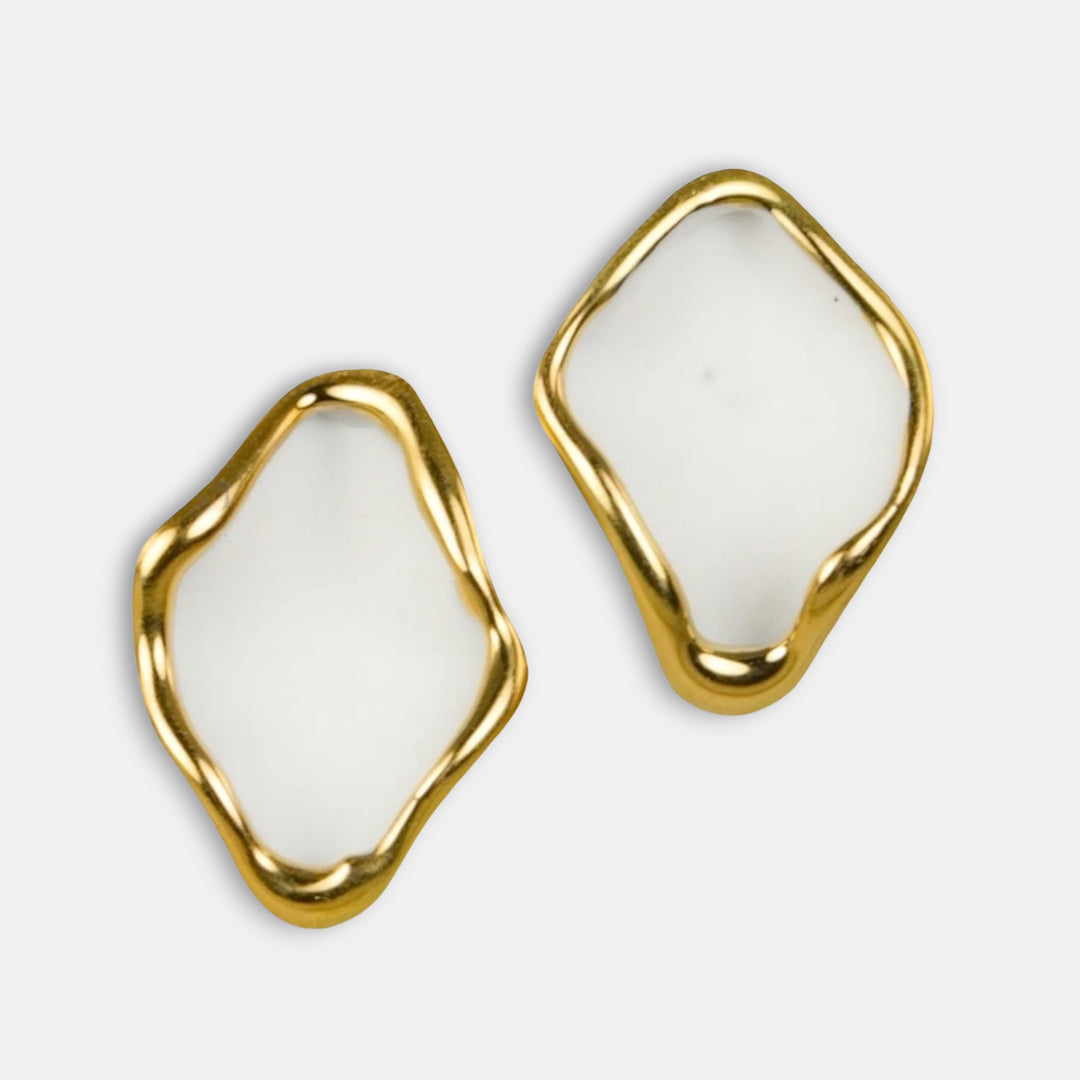 Gold-framed white earrings by freakyfoxx on a light gray background