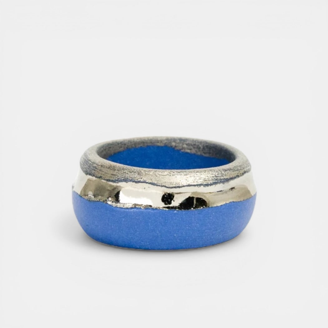 Silver and blue ring on a light gray background