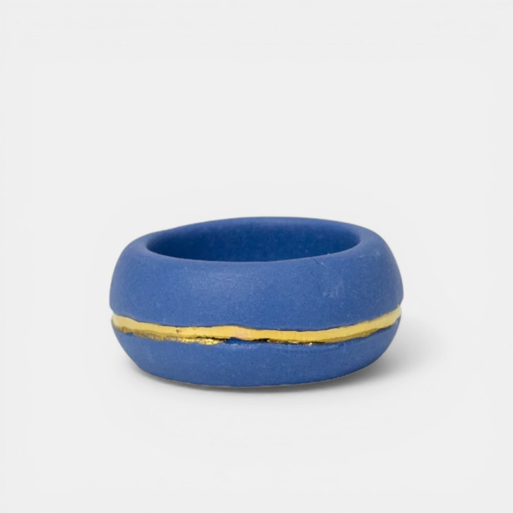 Blue ring with a gold band on a white background