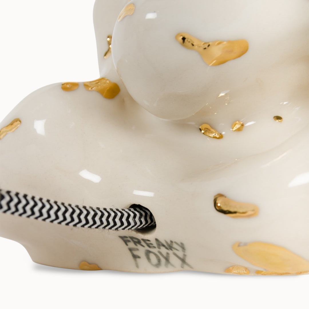 Close-up of the ceramic lamp base featuring gold-painted accents, highlighting its handcrafted luxury.
Keraminio šviestuvo pagrindo stambus planas su auksinėmis detalėmis, pabrėžiantis jo rankų darbo prabangą.