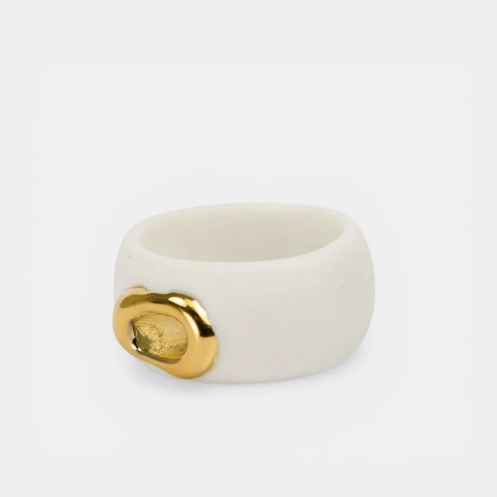White ceramic ring with gold emblem on a white background