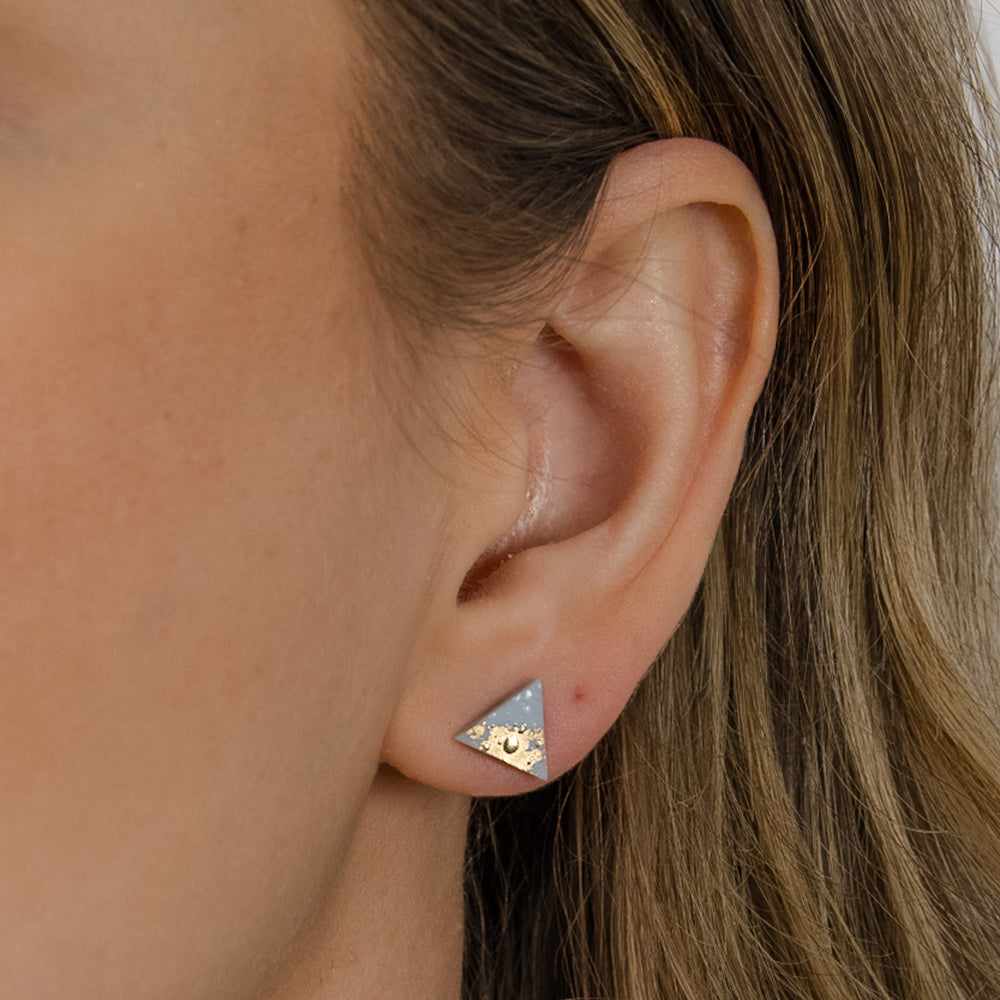 Light blue ceramic earring with gold on ear