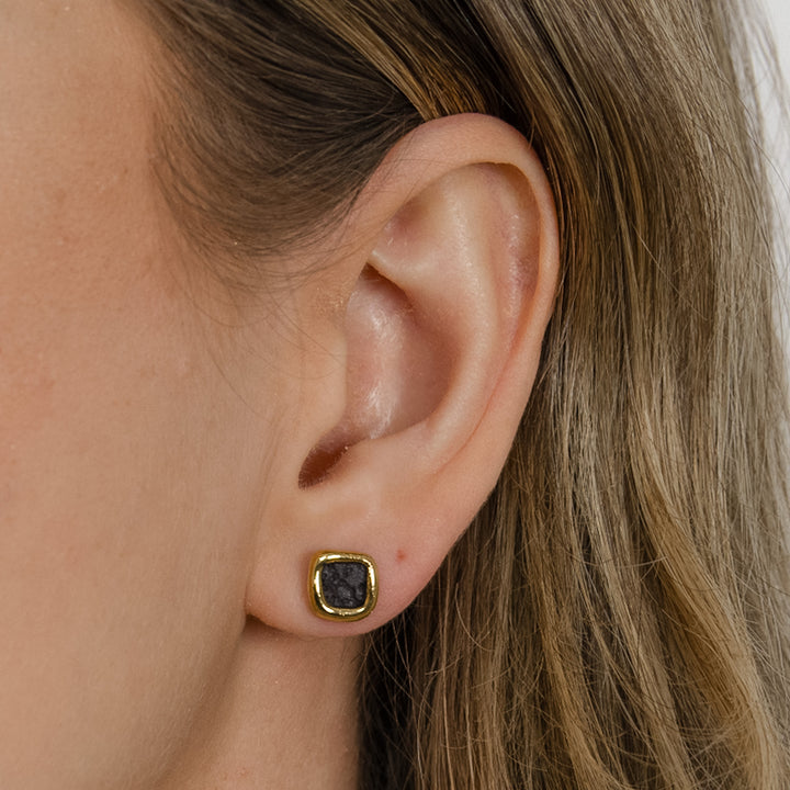 Close-up of an ear wearing black ceramic earrings