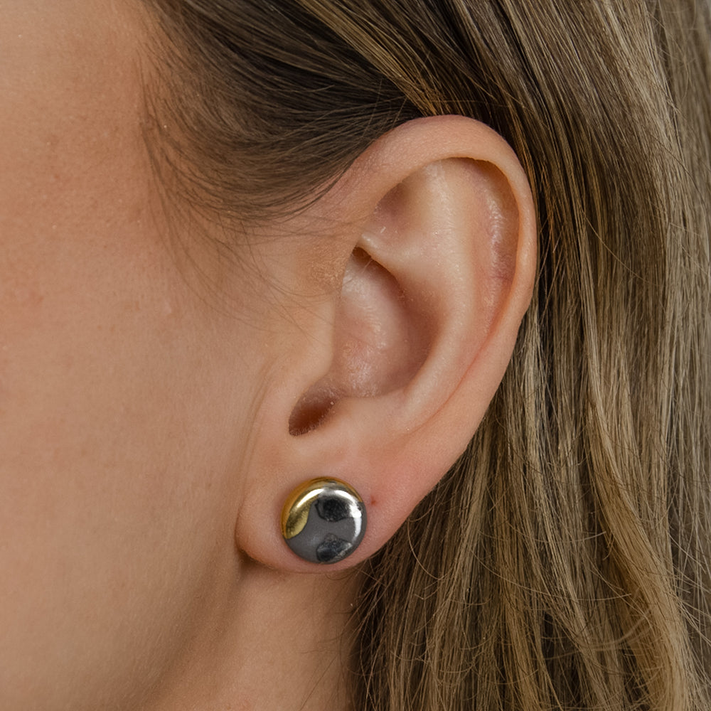 Ausies su sidabriniu auskaru su atspindinčiu paviršiumi stambus planas.