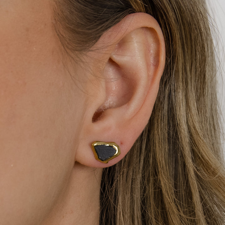 Black ceramic earring with gold on ear