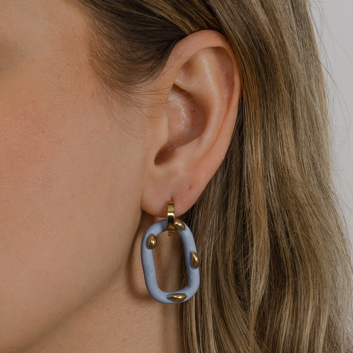 Ausies su lengvais, unikaliais auskarais su auksiniais akcentais stambus planas.