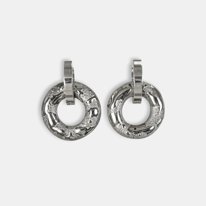 Pora sidabrinių žiedinių auskarų iš freakyfoxx šviesiai pilkame fone