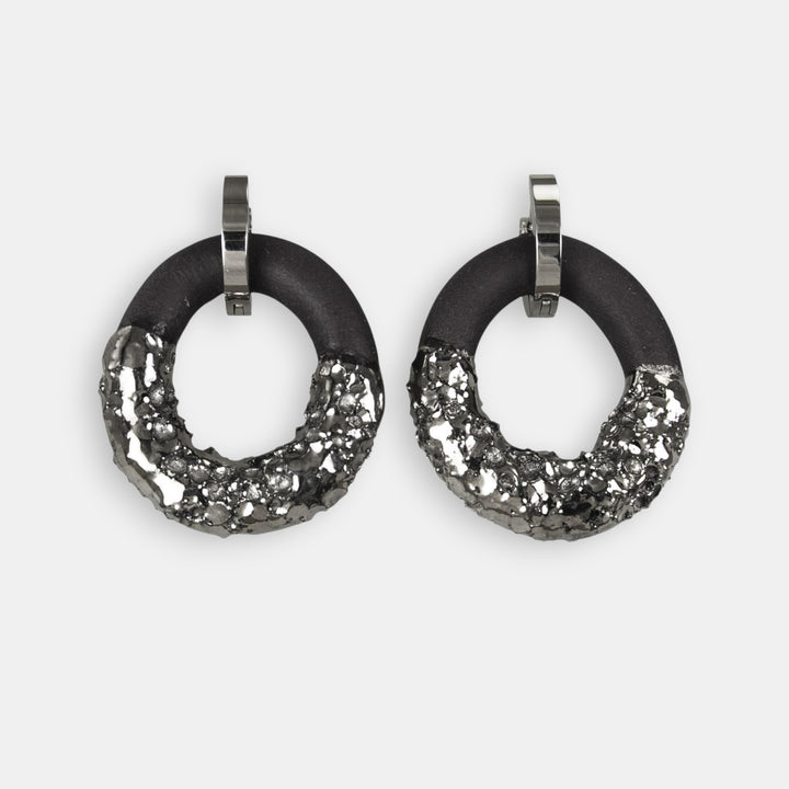 Pair of black and silver hoop earrings on a white background
