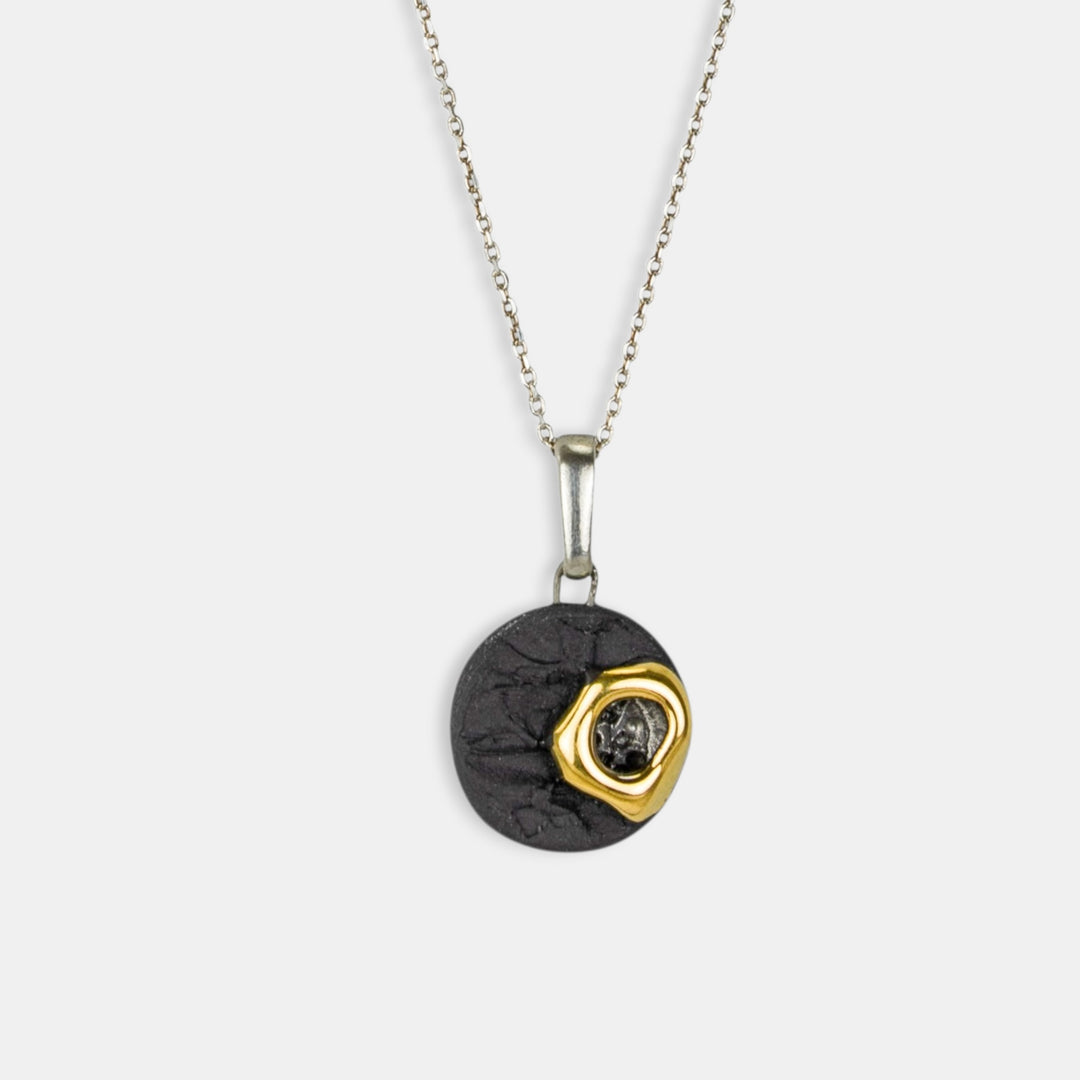 Necklace with a black and gold pendant on a white background 