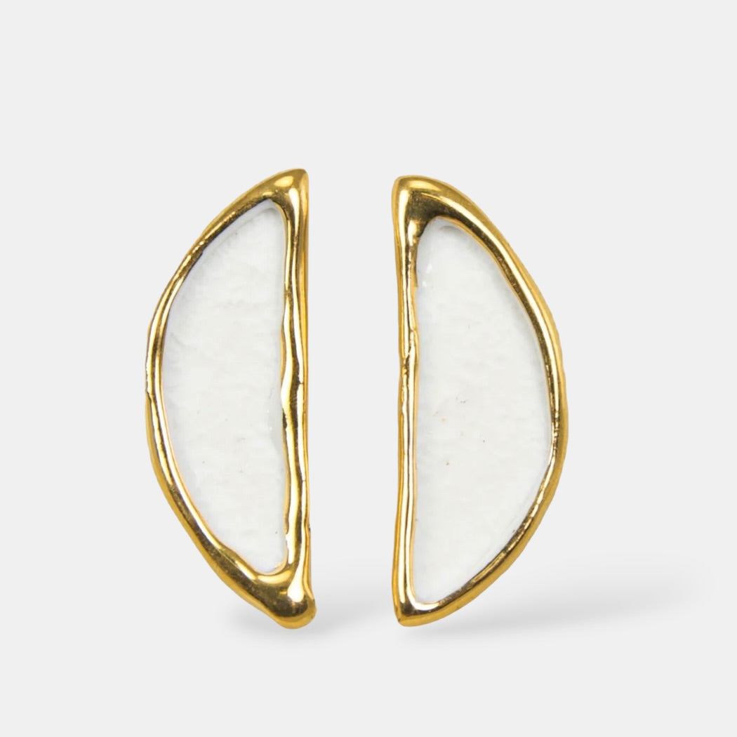 Auksiniai auskarai su baltu porcelianu šviesiai pilkame fone