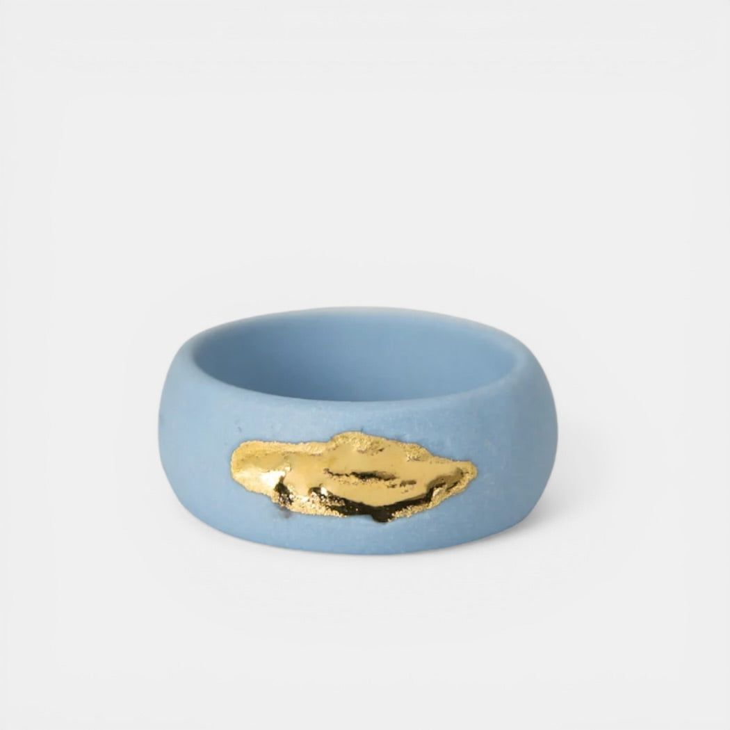 Blue porcelain ring with gold accent on a white background
