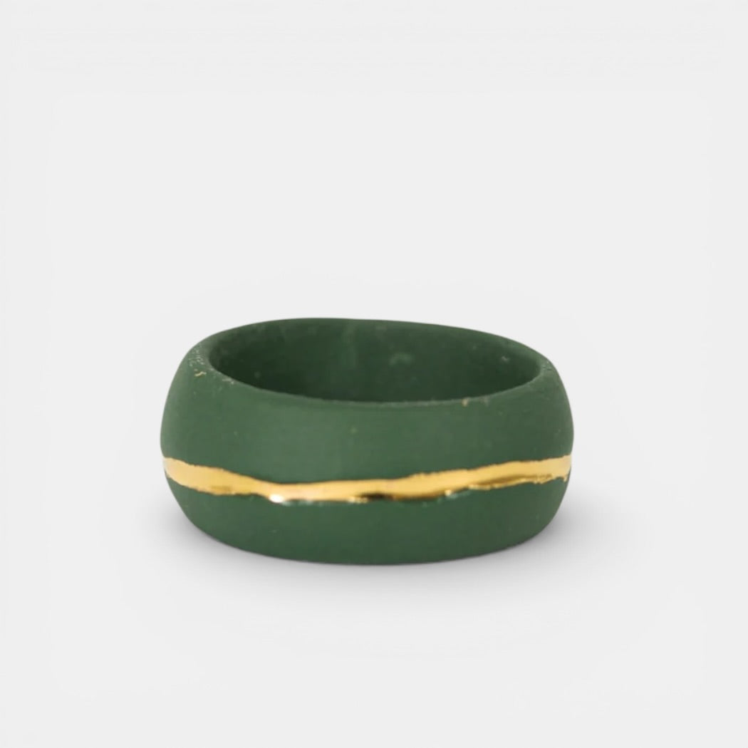 Green ring with a gold stripe on a white background