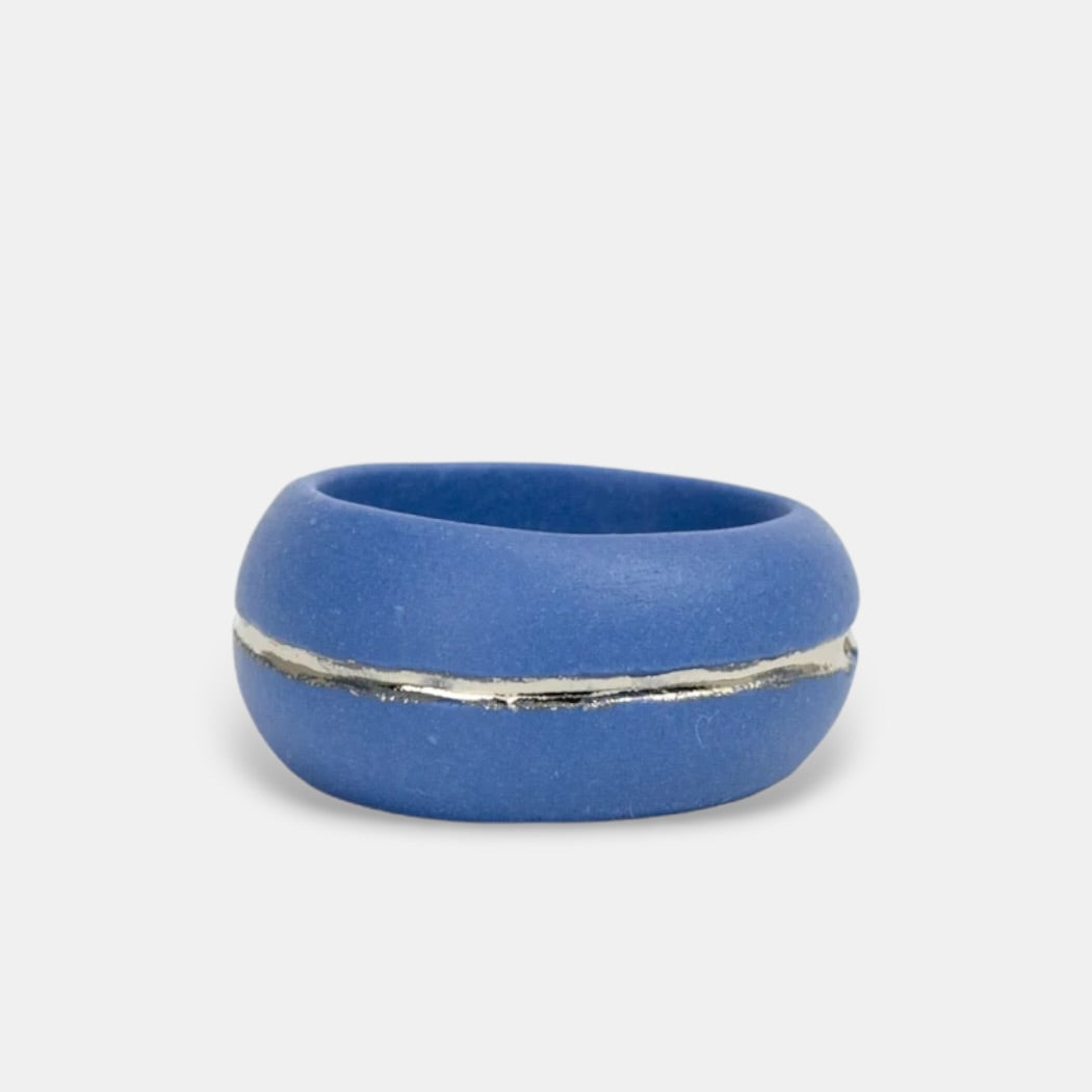 Blue ring with a silver band on a light gray background