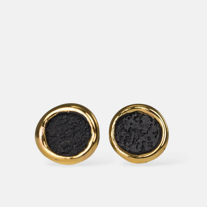 Pair of porcelain round earrings with black center and gold rim on a white background