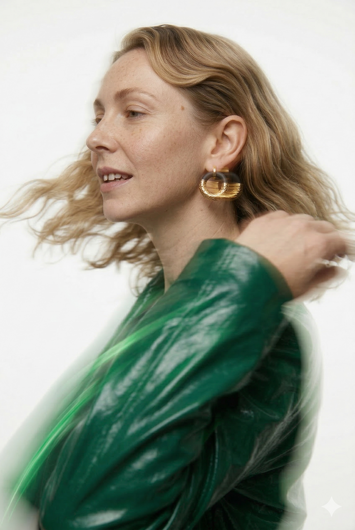 Woman wearing a green jacket and black porcelain earrings with gold by freakyfoxx against a white background