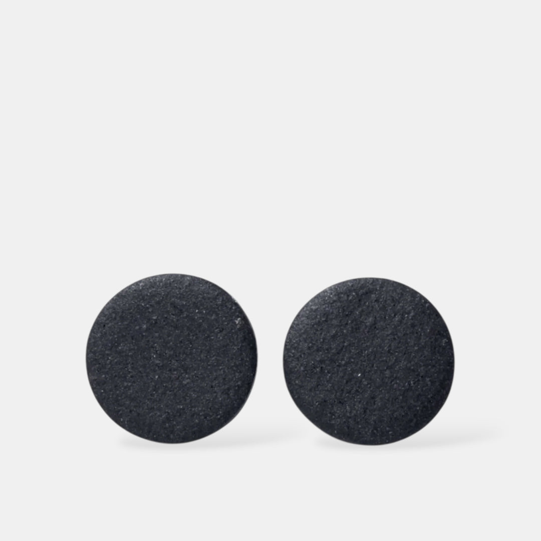 Pora juodų matinių apvalių auskarų iš freakyfoxx šviesiai pilkame fone