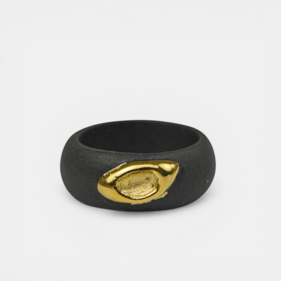 Black ring with a gold emblem on a white background